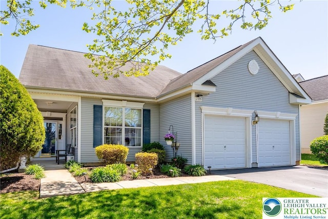 view of front of property featuring a front lawn, aphalt driveway, and an attached garage