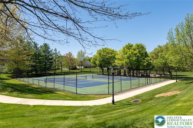 view of sport court with a yard and fence