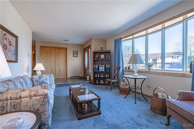 carpeted living area featuring visible vents and baseboards