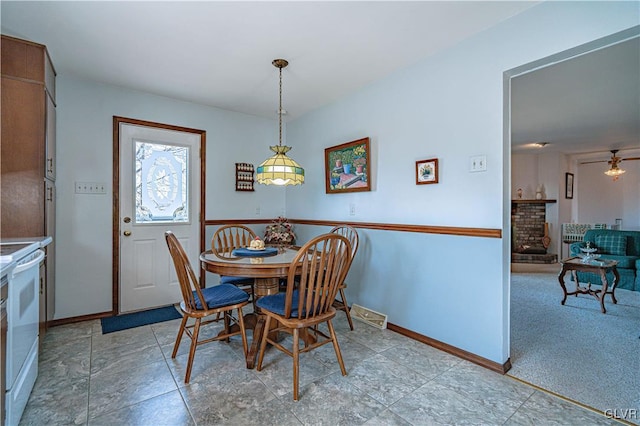 dining area with a fireplace and baseboards