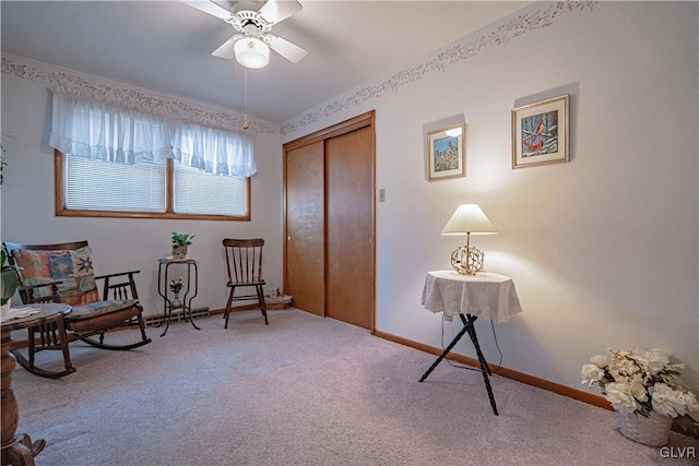 living area with carpet flooring, ceiling fan, and baseboards