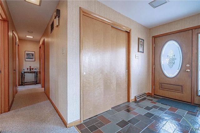 entryway with visible vents, baseboards, and wallpapered walls