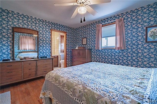 bedroom featuring a ceiling fan, dark wood-style flooring, and wallpapered walls