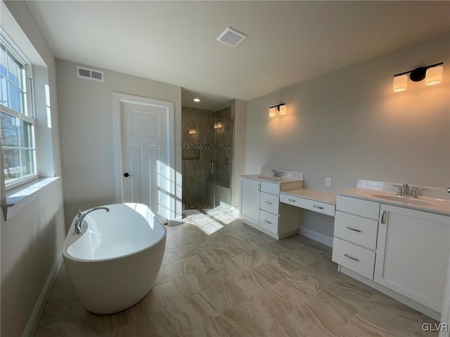 full bathroom featuring visible vents, a shower stall, vanity, and a freestanding tub