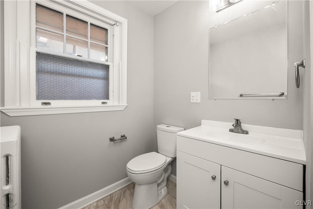 bathroom featuring baseboards, toilet, and vanity