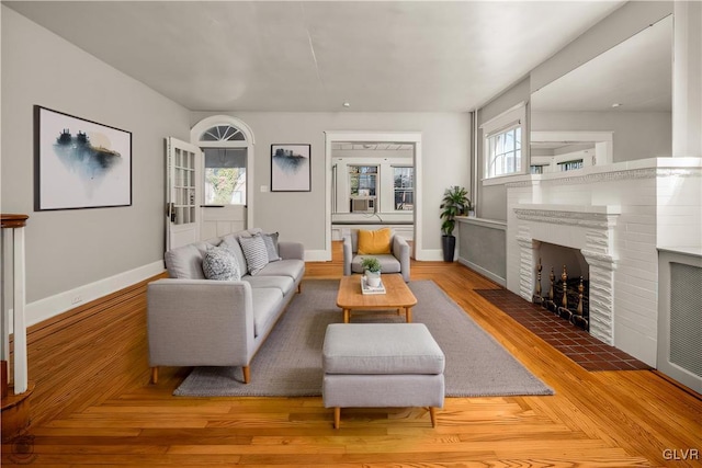 living room with a fireplace, parquet floors, and baseboards