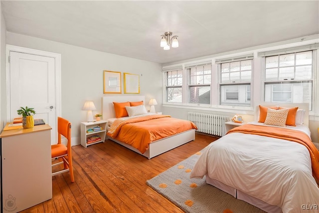 bedroom featuring radiator heating unit and wood-type flooring