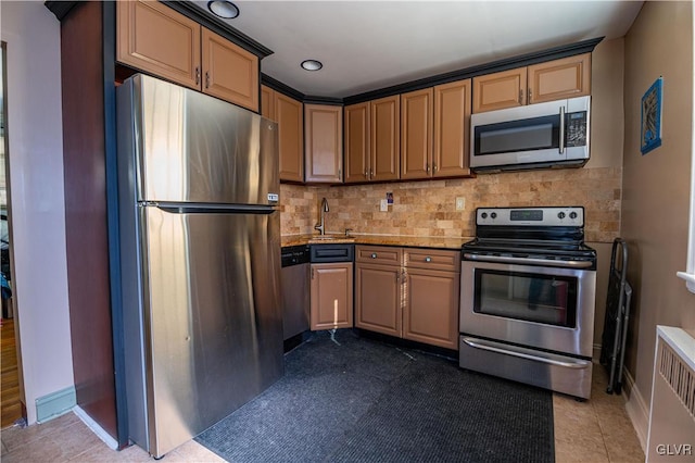 kitchen featuring light tile patterned floors, decorative backsplash, recessed lighting, appliances with stainless steel finishes, and a sink