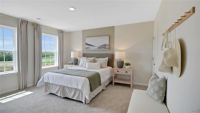 bedroom with light colored carpet, visible vents, and baseboards