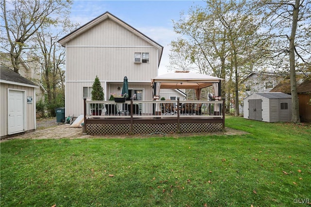 back of property featuring a gazebo, a storage unit, an outbuilding, and a wooden deck