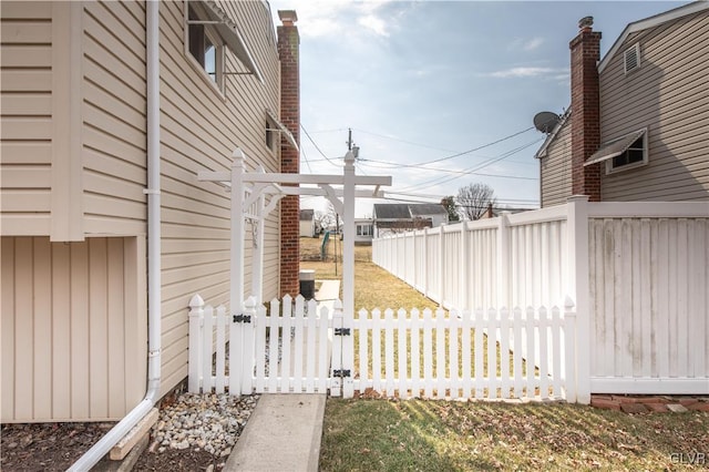 view of side of home with a gate and fence