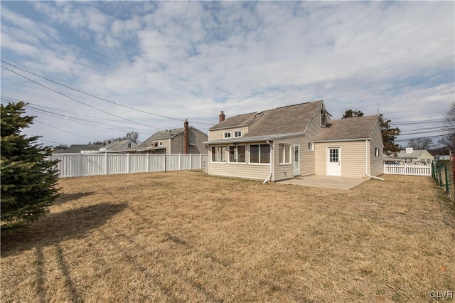 rear view of house featuring a yard, a fenced backyard, and a patio area