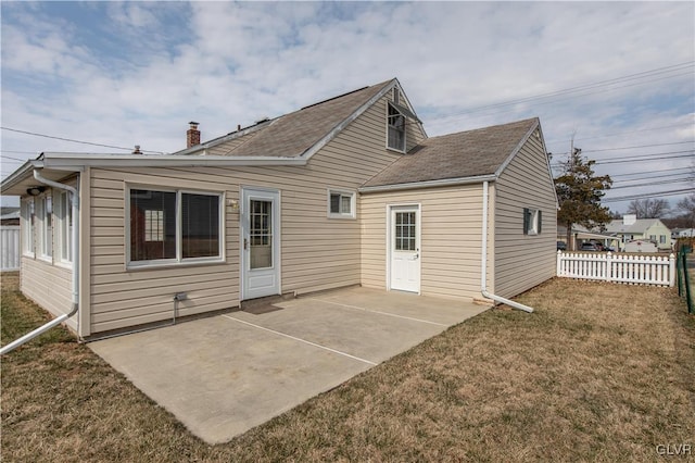 rear view of property featuring a patio area, a yard, and fence