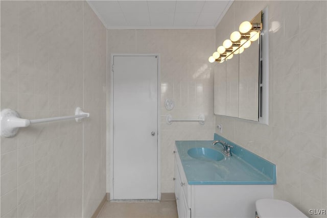 bathroom with vanity, tile walls, toilet, and ornamental molding