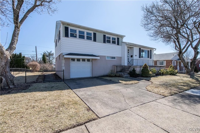 split level home featuring a garage, a porch, driveway, and fence