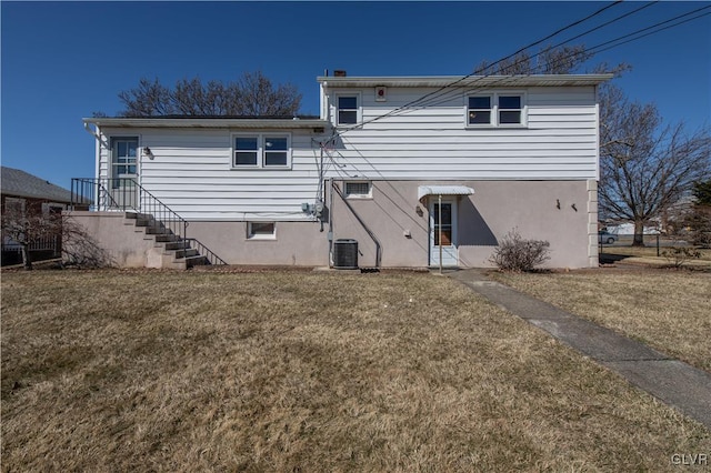 rear view of house featuring central AC and a yard