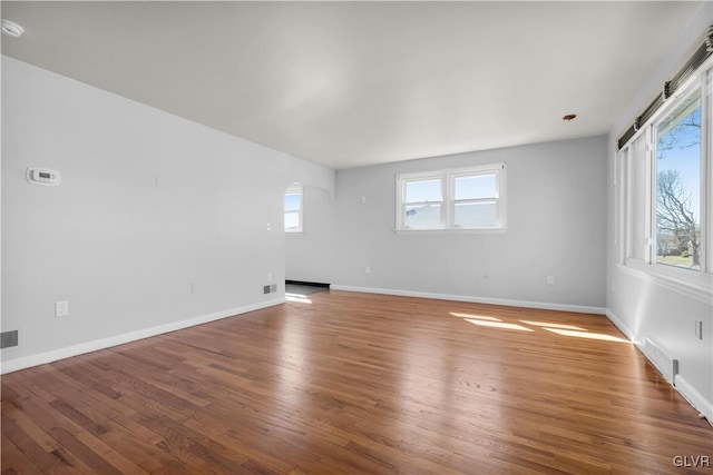 spare room featuring visible vents, wood finished floors, and baseboards