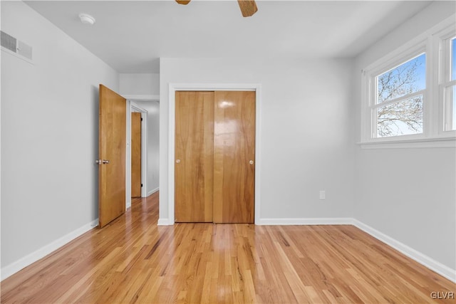 unfurnished bedroom with light wood finished floors, visible vents, ceiling fan, and baseboards