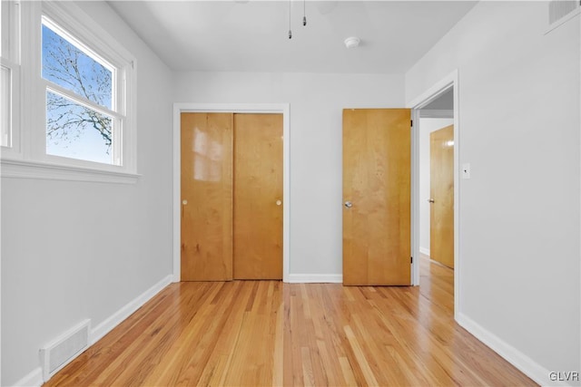 unfurnished bedroom featuring visible vents, baseboards, and light wood finished floors