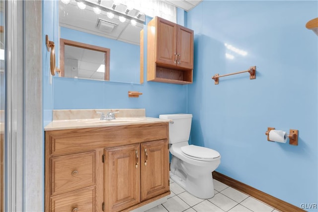 bathroom with vanity, tile patterned floors, toilet, and baseboards