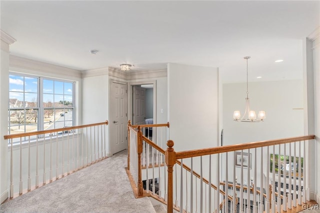 corridor featuring an upstairs landing, light colored carpet, and a chandelier