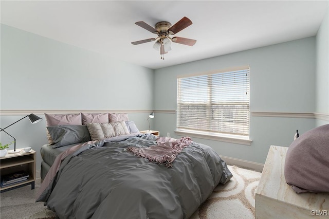 bedroom with a ceiling fan, baseboards, and carpet floors