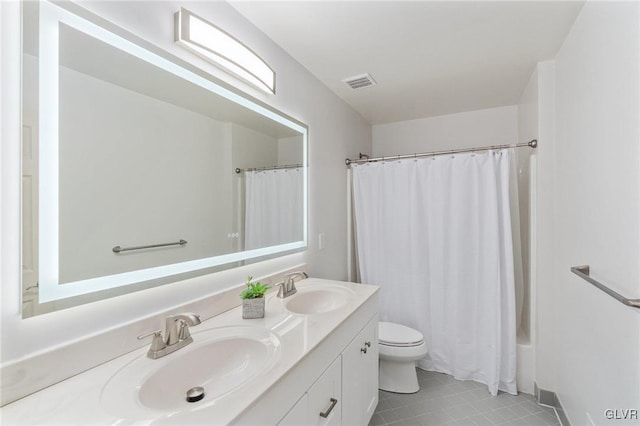 full bath featuring double vanity, toilet, visible vents, and a sink