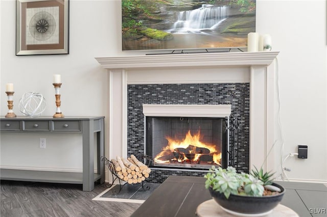 room details featuring a tile fireplace and wood finished floors