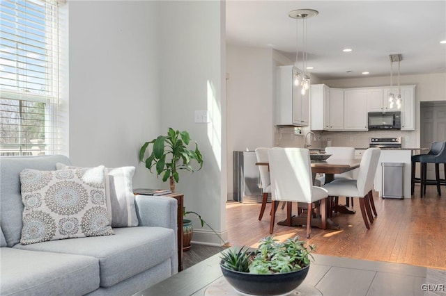 dining space with recessed lighting, wood finished floors, and baseboards