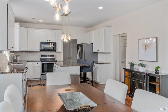 dining space with recessed lighting and wood finished floors