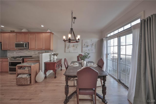 dining space featuring light wood finished floors, a chandelier, recessed lighting, and crown molding