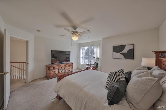 bedroom with a ceiling fan, baseboards, and light carpet