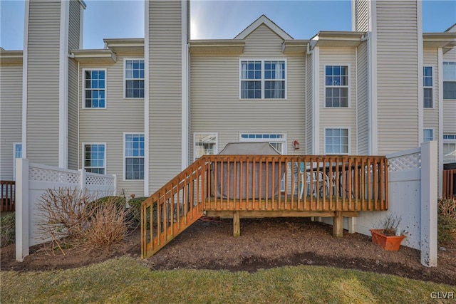 rear view of property with a chimney and a deck