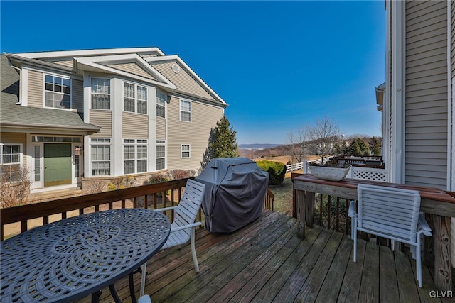 wooden deck featuring a mountain view and a grill