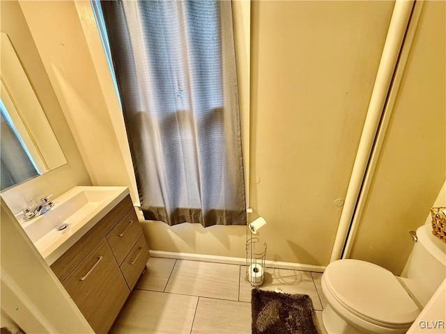 bathroom with baseboards, toilet, vanity, and tile patterned flooring