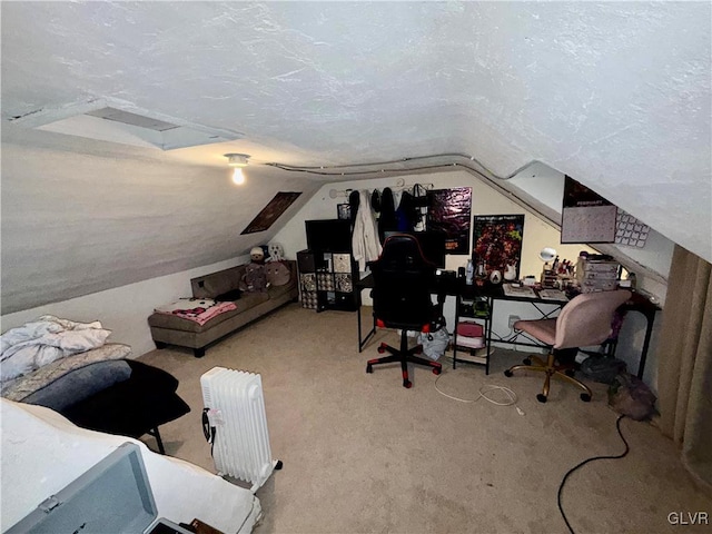 home office with carpet floors, a textured ceiling, attic access, and vaulted ceiling