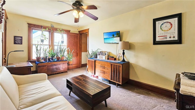 living room featuring baseboards, carpet, and ceiling fan