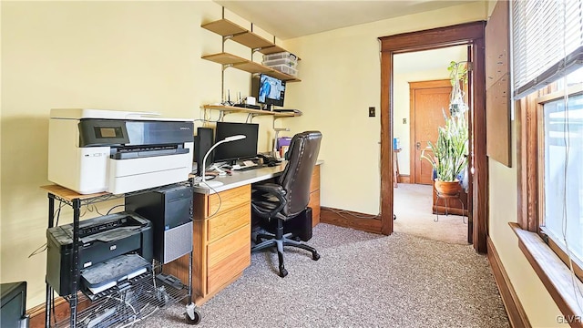 home office with baseboards and light colored carpet