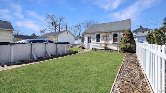 view of yard featuring a covered pool and fence