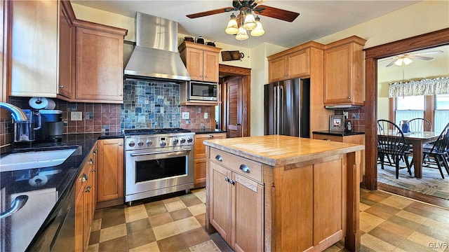 kitchen with tasteful backsplash, light floors, stainless steel appliances, wall chimney exhaust hood, and a sink