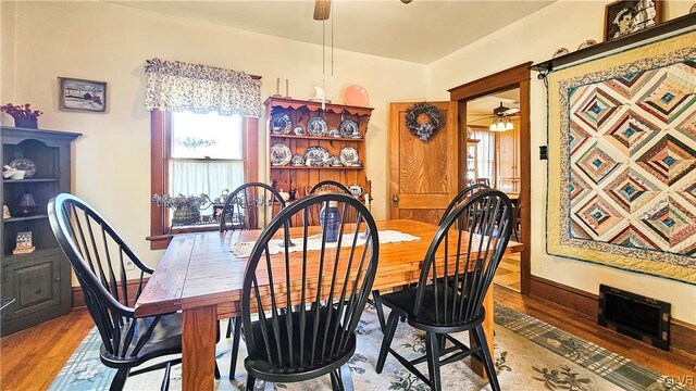 dining room featuring a ceiling fan, wood finished floors, baseboards, and a wealth of natural light