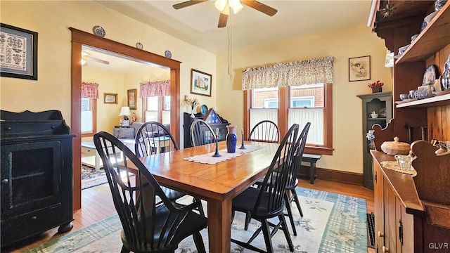 dining room with baseboards, a ceiling fan, and light wood-style floors