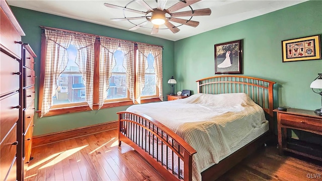 bedroom featuring baseboards, ceiling fan, and wood-type flooring