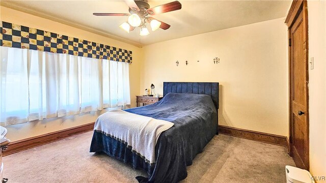 carpeted bedroom with baseboards and a ceiling fan