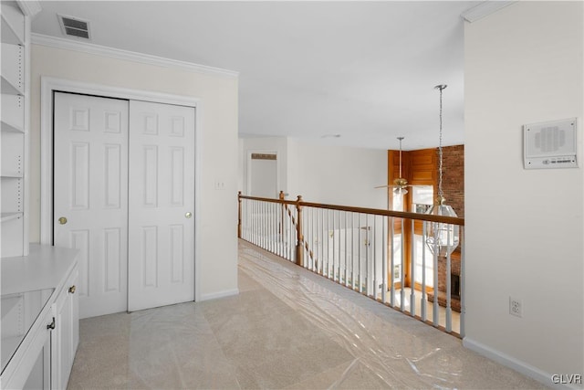 hall featuring visible vents, baseboards, and crown molding