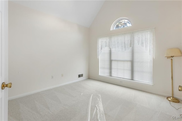 unfurnished room with vaulted ceiling, visible vents, and carpet floors