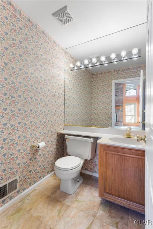 bathroom featuring visible vents, wallpapered walls, toilet, and vanity