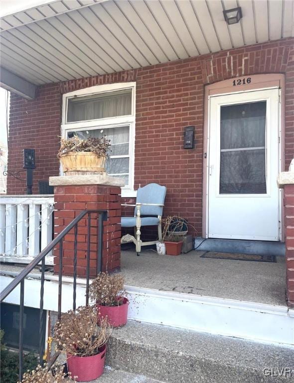 doorway to property with brick siding