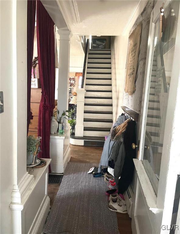 mudroom with wood finished floors and ornate columns