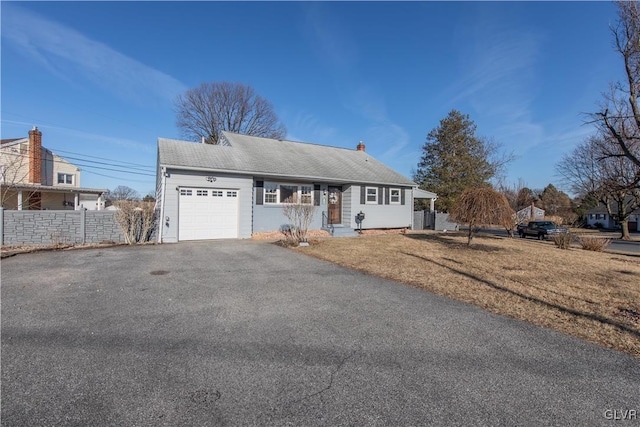 ranch-style house with a front lawn, fence, aphalt driveway, a chimney, and an attached garage